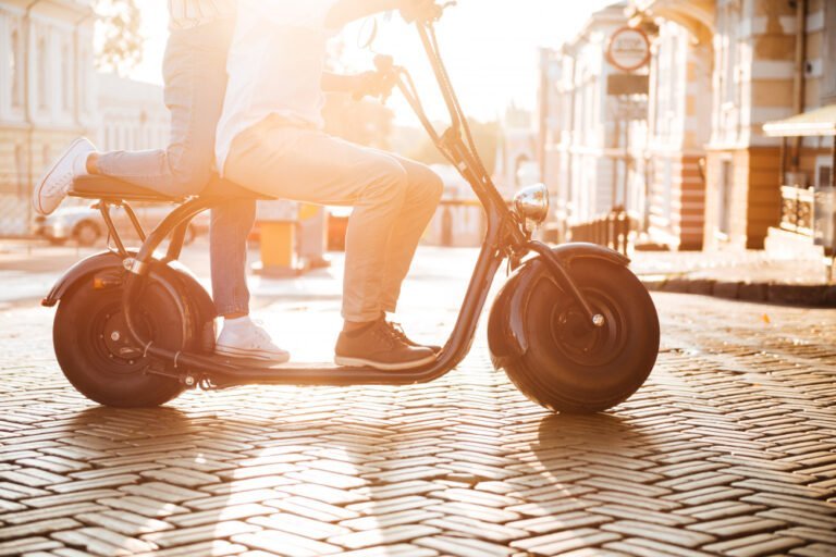 cropped side view young african couple rides moderm motorbike street